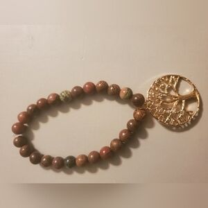 Handmade by my daughter. Brown wooden bead bracelet with Tree of Life Charm.